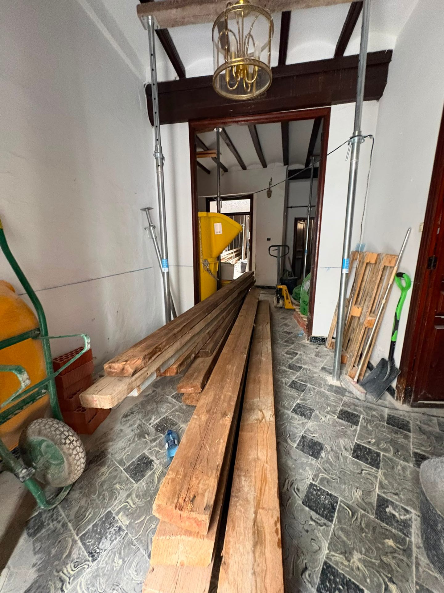 Capítulo 04 · Vigas recuperadas Vigas de madera recuperadas de la propia casa, apoyadas en el suelo del zaguán para volver a usarse